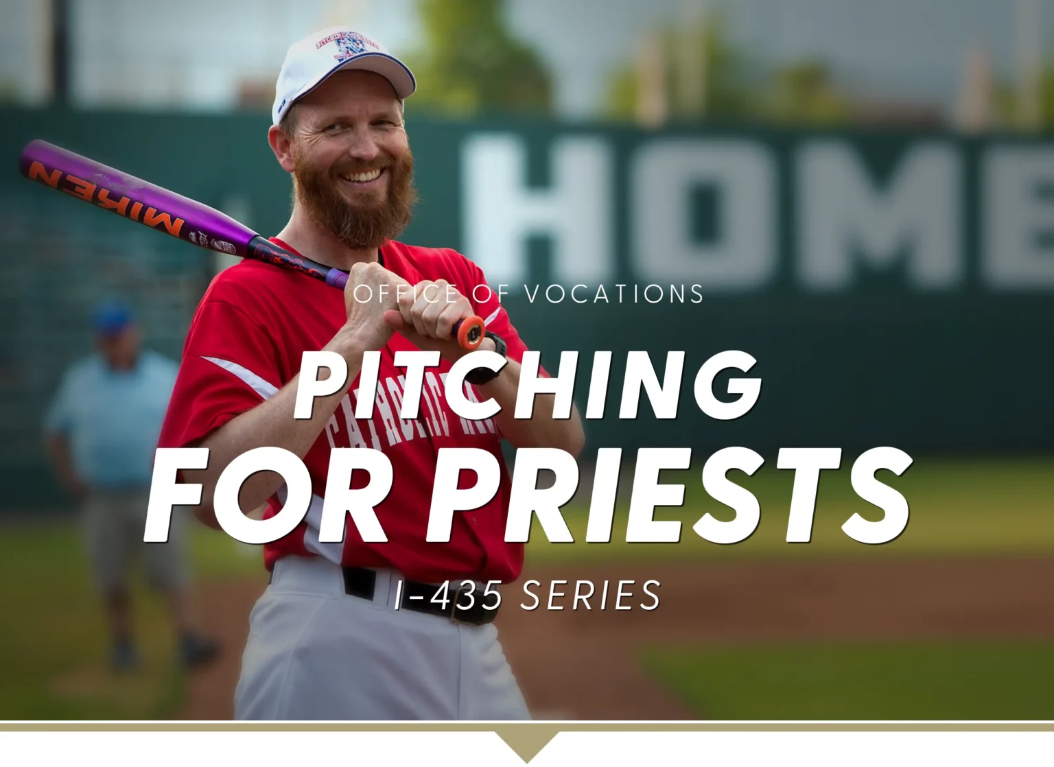 Pitching for Priests I-435 Series. Bearded man in full baseball uniform with bat on shoulder smiling at the camera on a baseball diamond.